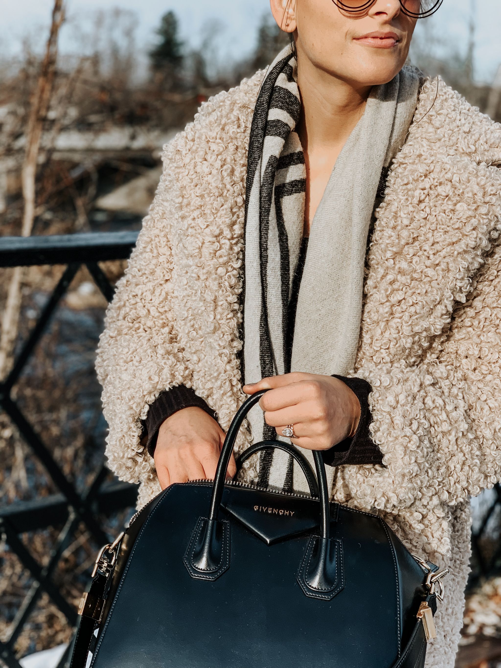 girl holding givenchy antigona bag and wearing teddy coat