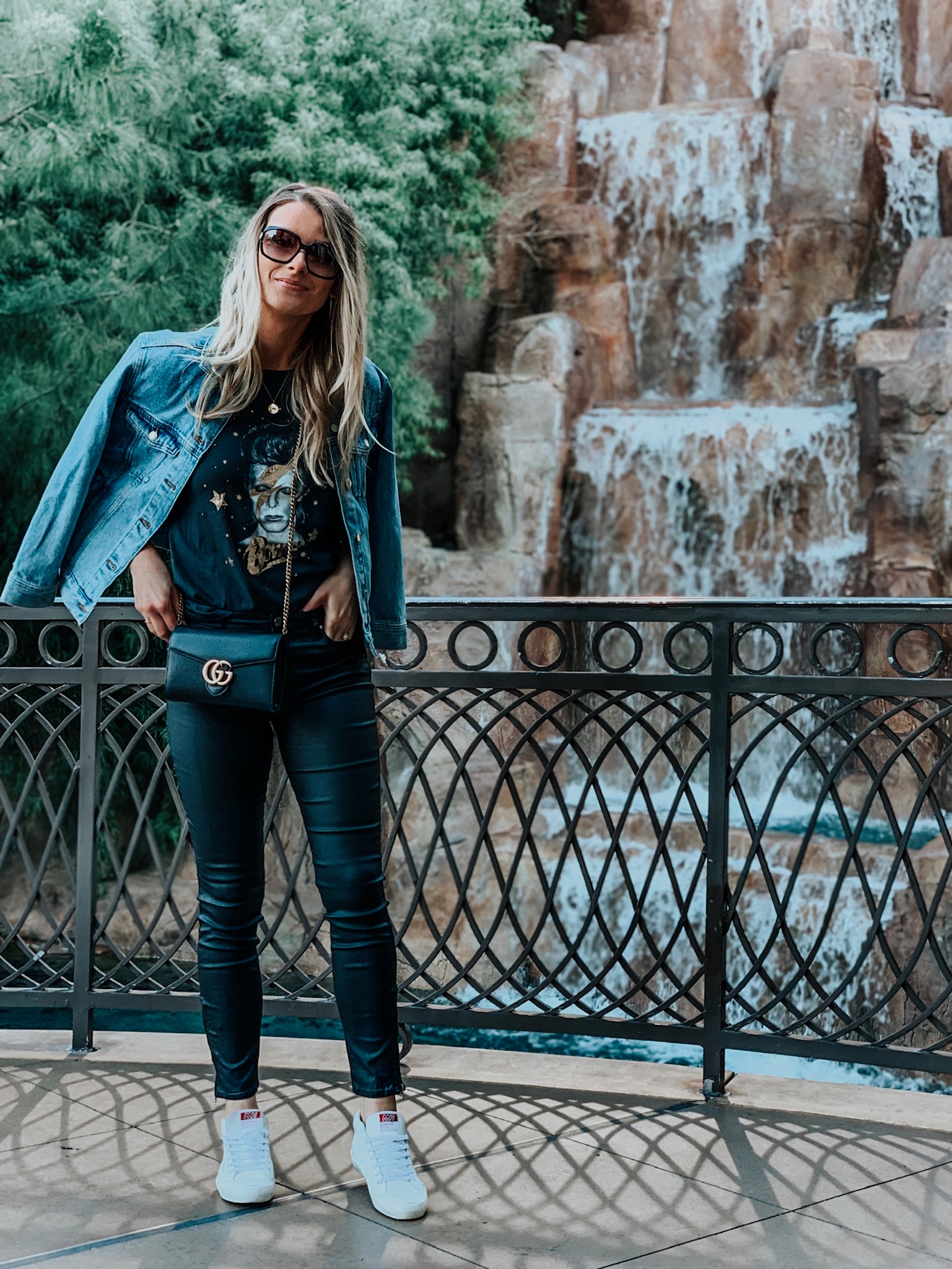 blogger wearing oversized denim jacket and black skinny pants with sneakers